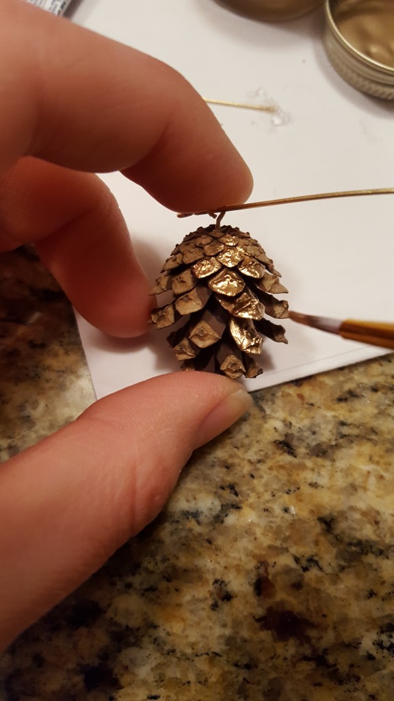 Paint a portion of the pinecone using gold leaf