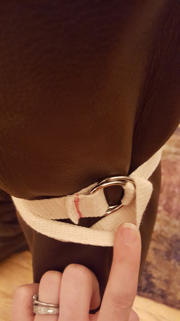 Put end of strap over one d ring and under the second d-ring. 