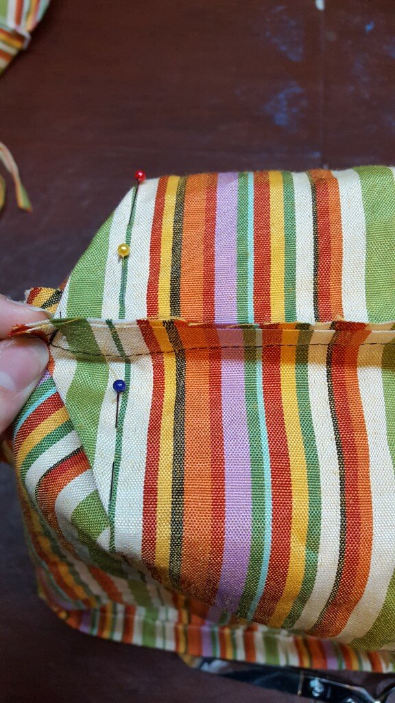 Pin across the corner, perpendicular to the seams. 