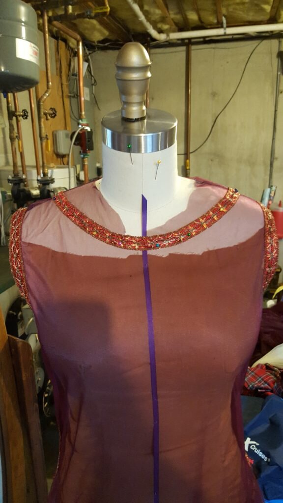 Pin gentle curving neckline matching the play of the trim. 