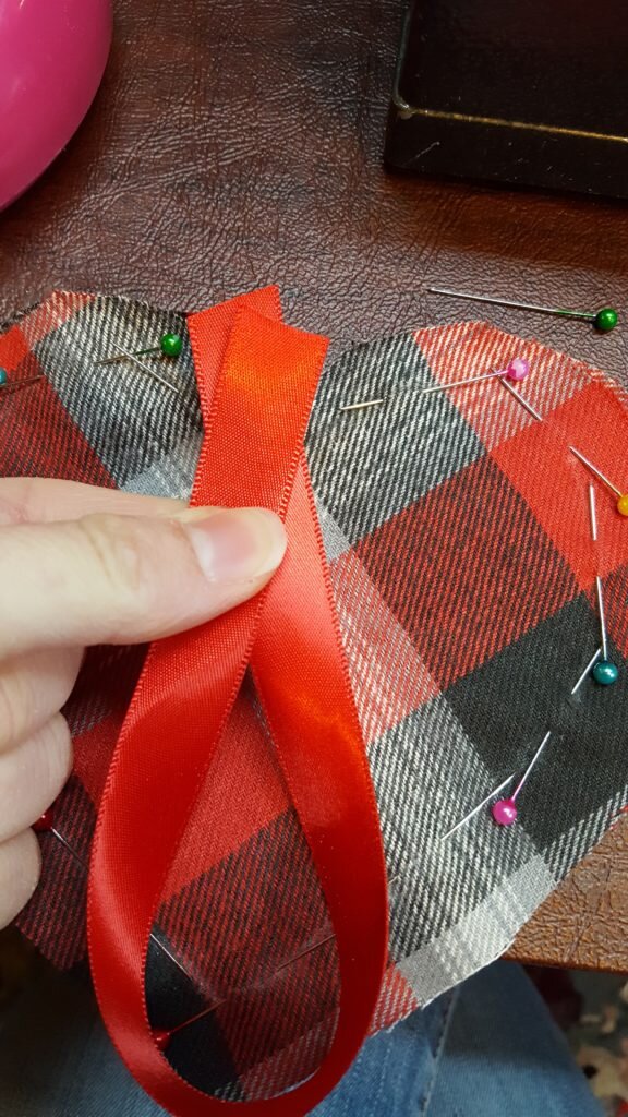Pin ribbon inside heart. 