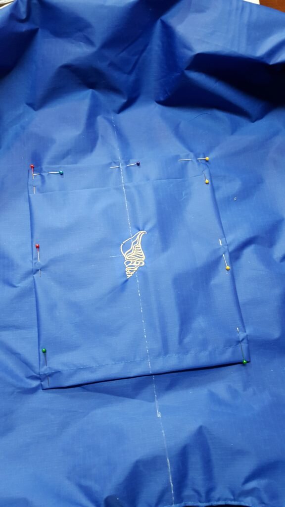 Fold under edges 1/2". Pin pocket to center back of bag. Top stitch around edges. 