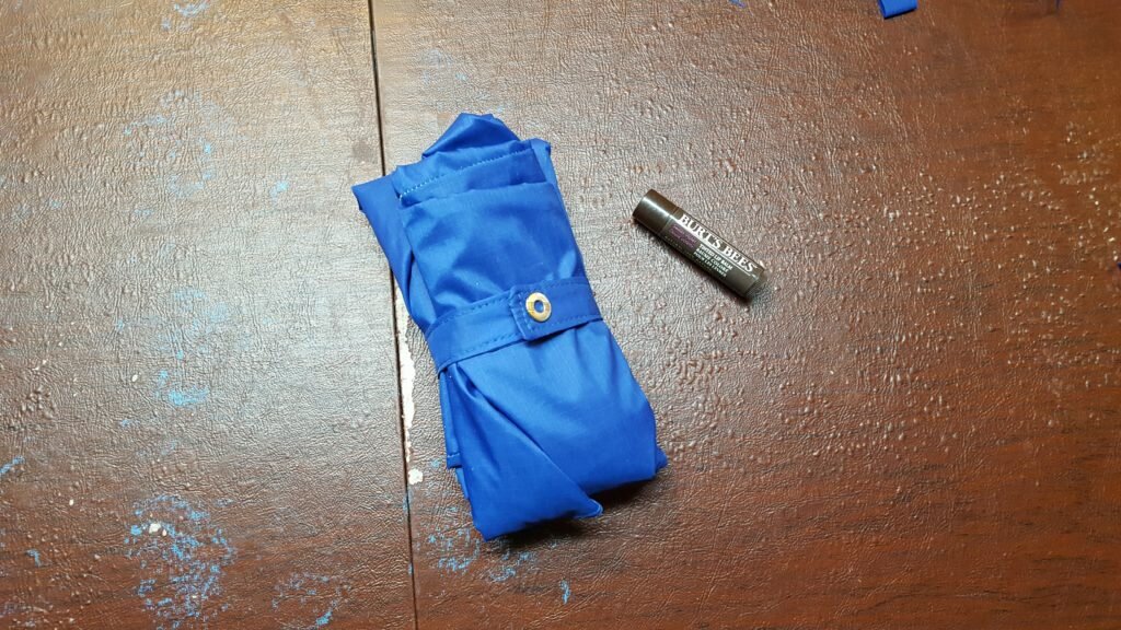 Snaps fastened around the bag. It folds up fairly small for such a large bag!